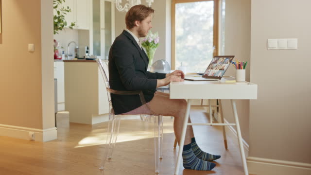 Funny Clip: Businessman Wearing Jacket and No Pants Uses Laptop and Conference Video Call Software App for Board of Directors Online Meeting. Remote Work, Work at Home, Home Office Concept. Side View